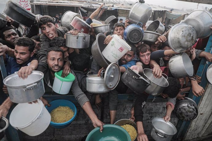 January 17, 2025, Khan Younis, Gaza Strip, Palestinian Territory: Palestinians gather to receive food cooked by a charity kitchen, before a ceasefire between Hamas and Israel takes effect, in Khan Younis, in the southern Gaza Strip.