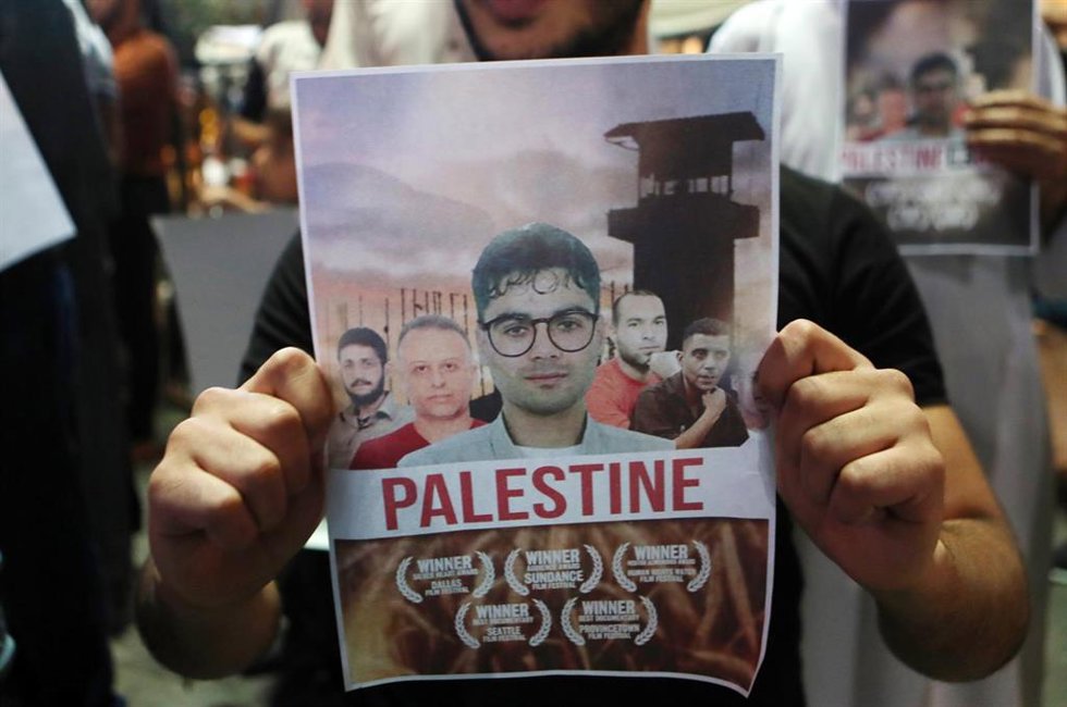 Archivo - Zakaria Zubeidi, primero por la derecha, en un cartel de protesta tras su fuga de una cárcel israelí