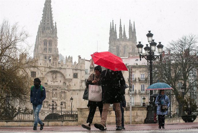 Archivo - Varias personas caminan por la calle mientras nieva, a 23 de febrero de 2023, en Burgos, Castilla y León (España). La Delegación del Gobierno ha activado la fase de alerta del Protocolo de coordinación de actuaciones ante situaciones meteorológi