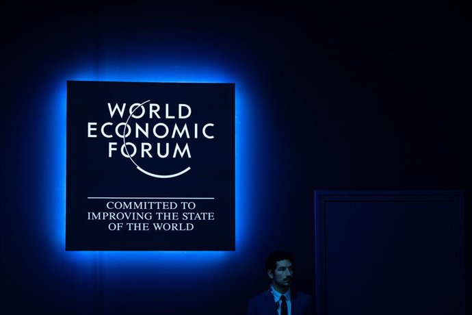 Archivo - 18 January 2024, Switzerland, Davos: A man stands under a World Economic Forum sign during of the Annual Meeting in Davos. Photo: Hannes P. Albert/dpa