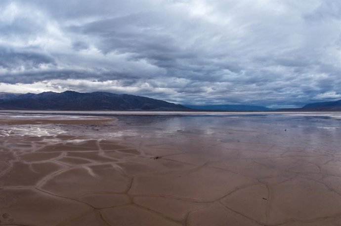 El barro agrietado y la sal en el fondo del valle del Parque Nacional del Valle de la Muerte en California pueden convertirse en un estanque reflectante después de las lluvias