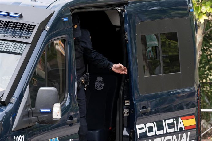Archivo - Un agente de la UIP de Policía Nacional cierra la puerta de un furgón policial en las inmediaciones donde se desalojan a 62 familias de cuatro portales, a 2 de junio de 2023, en Alcobendas, Madrid (España). 