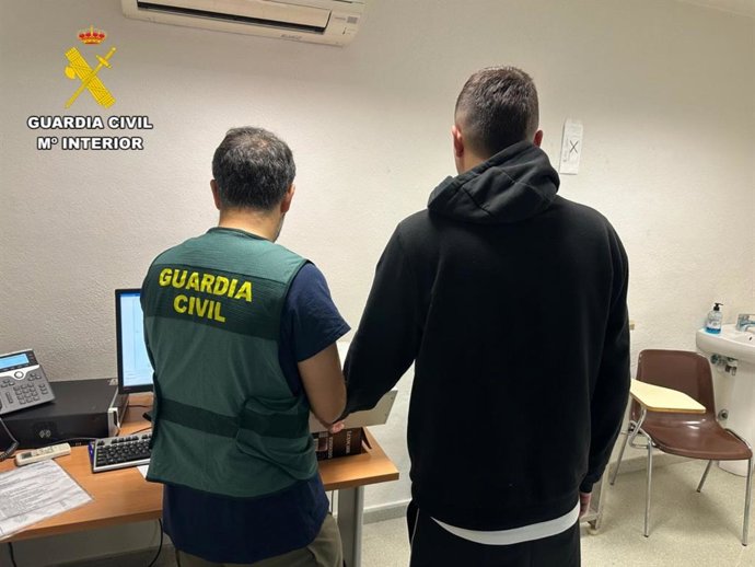 El detenido, junto a un agente.