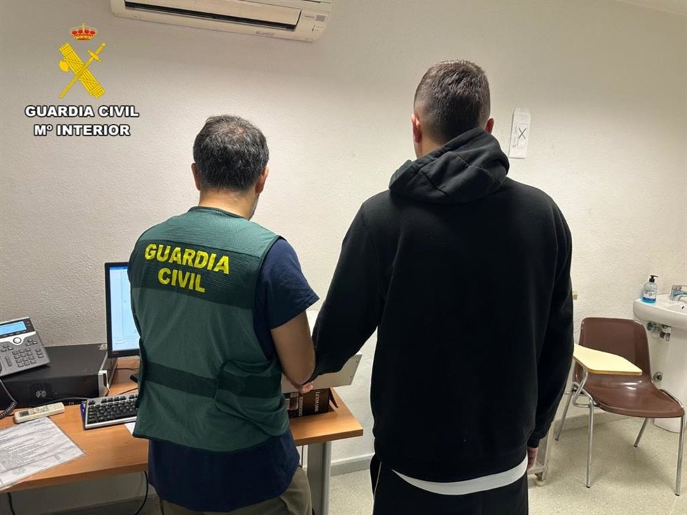 El detenido, junto a un agente.