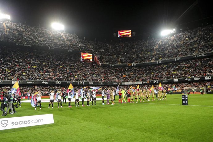 Los jugadores de la Real Sociedad y del Valencia se saludan antes del comienzo del partido en Mestalla