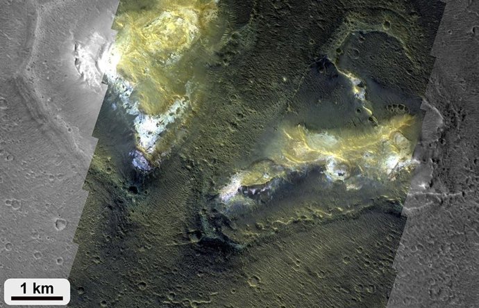 Dos montículos prominentes, que se elevan cientos de metros sobre las tierras bajas circundantes, muestran regiones brillantes ricas en minerales arcillosos.