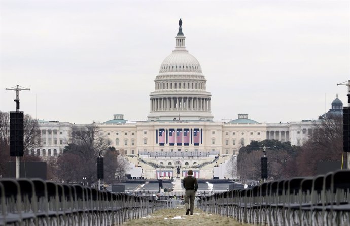 January 17, 2025, Washington Dc, Virginia, USA: A man walks through empty chairs placed for the 2025 Presidential Inauguration at the National Mall in front of U.S. Capitol on Friday, Jan. 17, 2025. The inauguration ceremony of Donald J. Trump will be mov