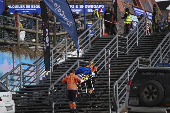 Dos personas llevan una camilla en la estación de esquí de Astún el pasado sábado tras el accidente ocurrido en el telesilla Canal Roya de la estación pirenaica. 