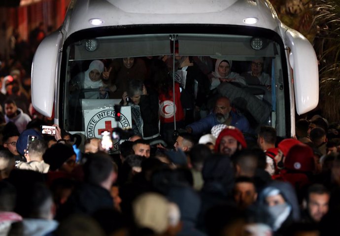 RAMALLAH, Jan. 20, 2025  -- People gather around a bus carrying released Palestinian prisoners in the town of Beitunia near the West Bank city of Ramallah, on Jan. 19, 2025. Israel released 90 Palestinian prisoners from Ofer prison, located west of Ramall