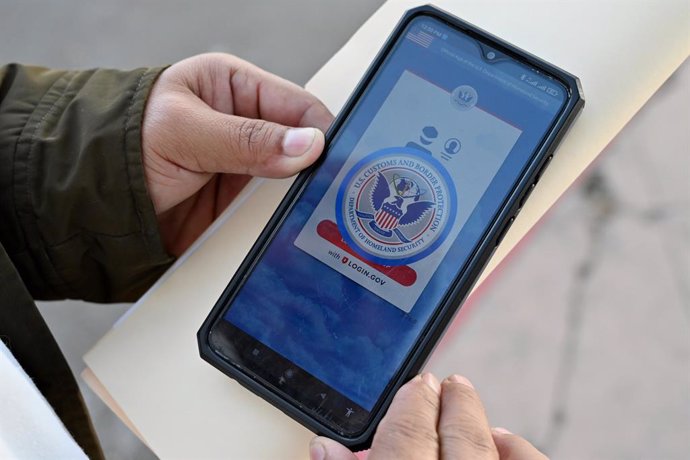 January 17, 2025, Tijuana, Baja California, Mexico: An asylum seeker with a cancelled appointment to enter the United States waits to speak to a Mexican immigration official to check his documents as he reviews the CBP One app at the El Chaparral border c