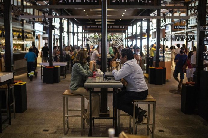 Archivo - Dos personas sentadas en la mesa de un restaurante