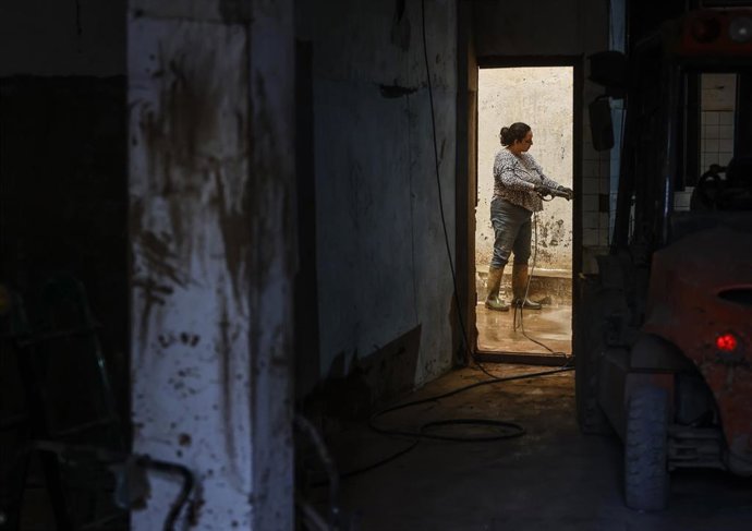 Archivo - Una mujer limpia una zona de barro, a 28 de noviembre de 2024, en Paiporta