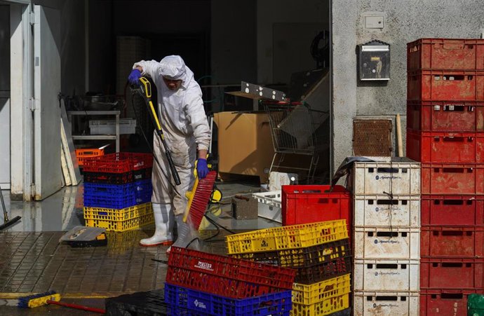 Archivo - Un hombre limpia una cestas en el polígono de Alfafar (ARCHIVO)