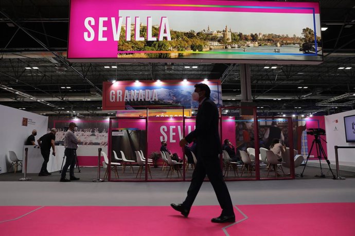 Archivo - Una persona camina junto al stand de Sevilla, en la edicion de Fitur de 2021, cuando la capital y la provincia compartían espacio. 