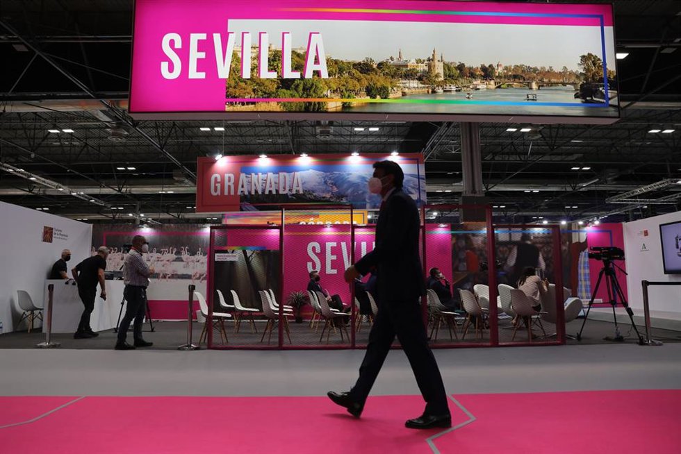 Archivo - Una persona camina junto al stand de Sevilla, en la edicion de Fitur de 2021, cuando la capital y la provincia compartían espacio.