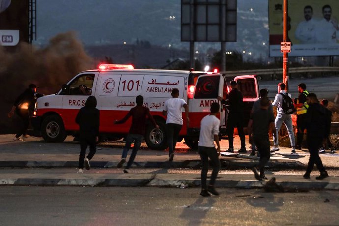 Archivo - Palestinos corren hacia una ambulancia durante los enfrentamientos con las fuerzas de seguridad israelíes en la aldea de Huwara, en Cisjordania