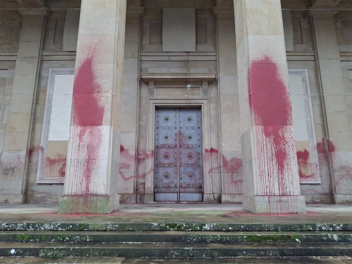 Puerta y columnas del Monumento a los Caídos de Pamplona vandalizados con pintura roja.
