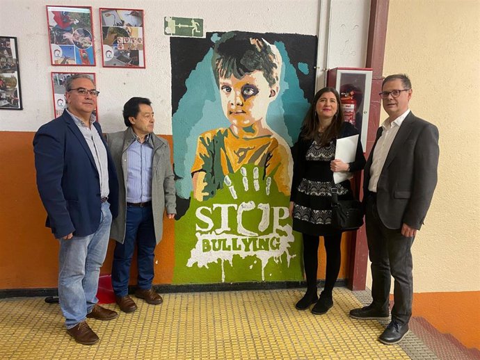 La concejala Miryam Rodríguez junto al psicólogo clínico  Hilario Garrudo y miembros de la dirección del IES Martínez Uribarri, junto a un mural contra el bullying.