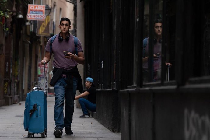 Archivo - Una persona camina con una maleta en el centro de Barcelona, a 17 de septiembre de 2024, en Barcelona, Catalunya (España)