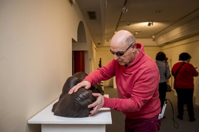 Una persona ciega toca una de las obras de Julián Rodríguez en el Museo Tifológico.