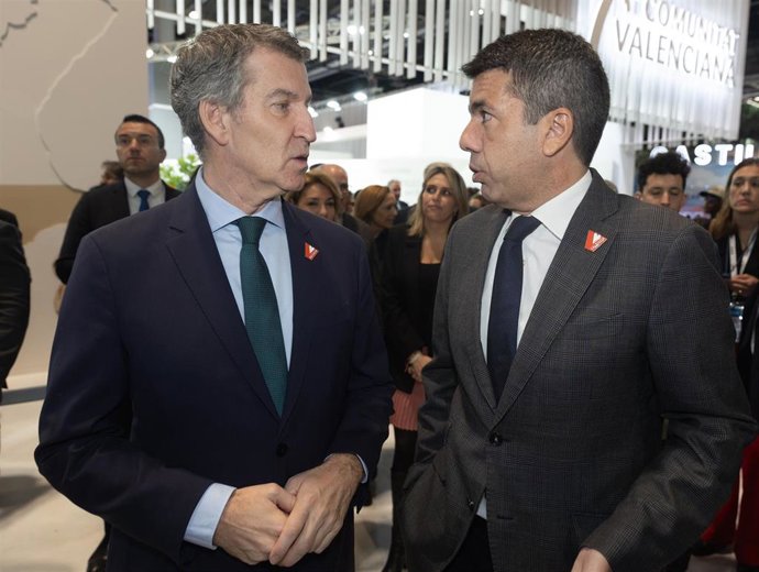 El presidente del Partido Popular, Alberto Núñez Feijóo (i) y el presidente de la Generalitat valenciana, Carlos Mazón (d), conversan en el estand de la Comunidad Valenciana, durante su visita a la Feria Internacional de Turismo (FITUR), en IFEMA Madrid, 