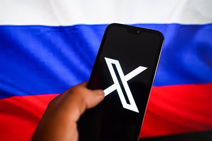 Archivo - November 3, 2024, Poland: In this photo illustration, a X logo is displayed on a smartphone with Russia's national flag in the background.