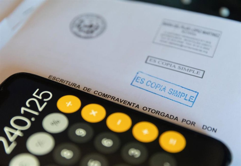 Archivo - Una calculadora y una escritura de compraventa de una hipoteca, a 2 de junio de 2022, en Madrid (España). 