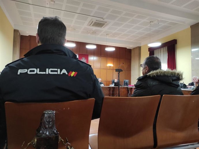 El acusado durante el juicio custodiado por agentes del CNP