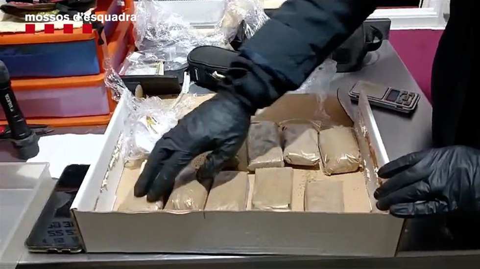 Un agente de los Mossos d'Esquadra efectúa un registro en un local de Cornell de Llobregat (Barcelona) usado como un punto de venta de hachís