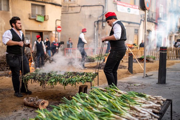 Diverses persones participen en el rostit de calçots durant la Festa de la Calçotada, a 26 de gener de 2025, a Valls, Tarragona, Catalunya (Espanya).