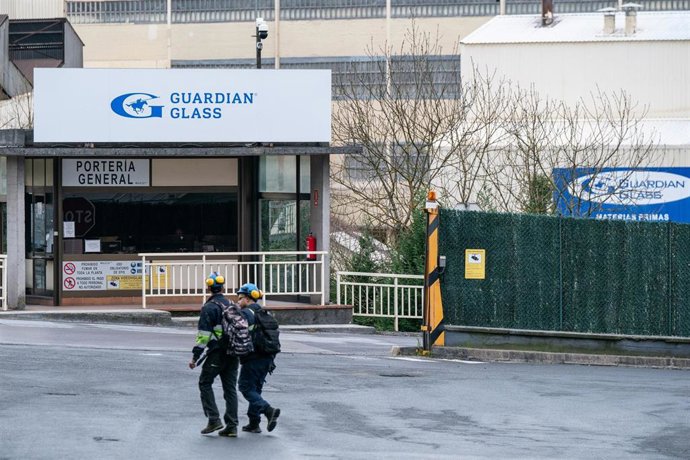 Dos personas caminan en el exterior de la fábrica de la multinacional Guardian