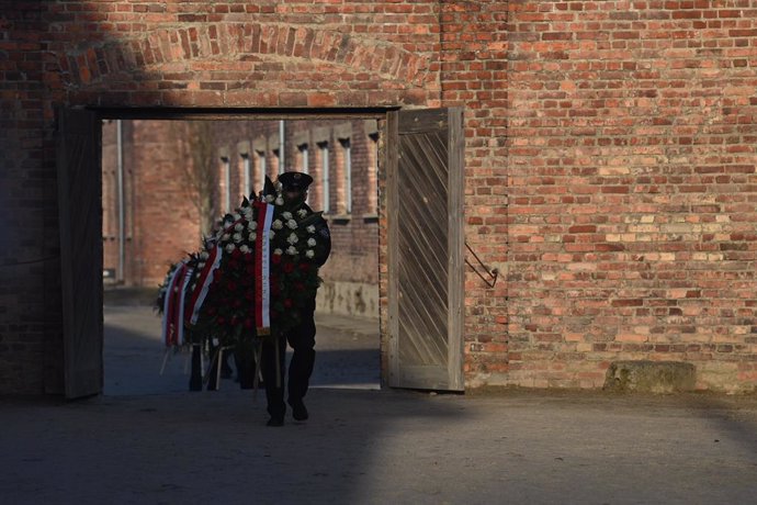 27 January 2025, Poland, Oswiecim: Wreaths are carried at the site of the former German concentration and extermination camp Auschwitz-Birkenau as part of the commemoration of the 80th anniversary of the camp's liberation. Delegations from over 40 countri