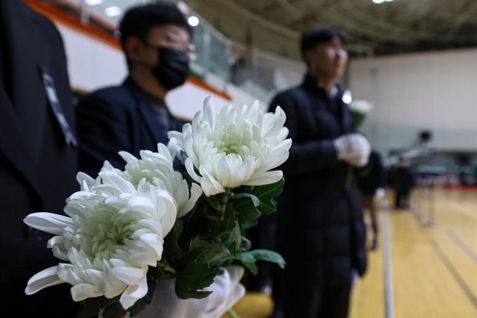 Imagen de archivo de varias personas depositando flores en recuerdo a las víctimas del accidente aéreo del avión de Jeju Air en Corea del Sur.