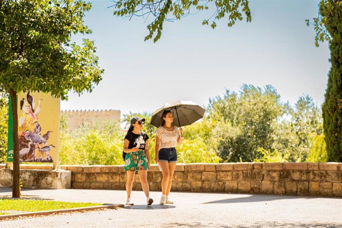 Archivo - Personas pasean por una calle en un día soleado. 