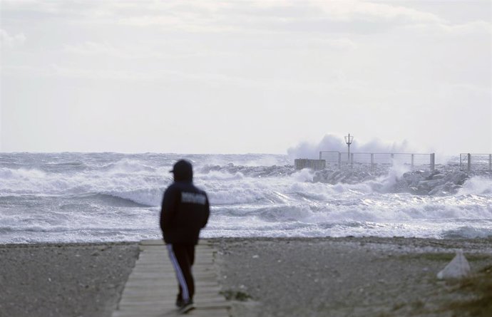 Archivo - Varias personas en la playa de la Malagueta con temporal (Foto de archivo).