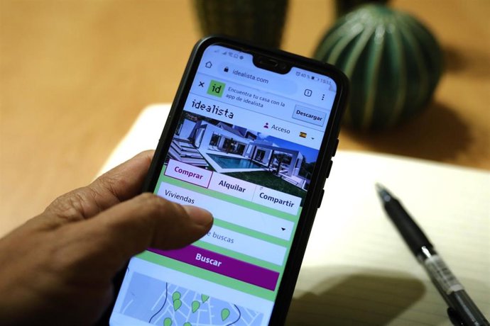 Archivo - Una persona hace uso de la aplicación móvil de Idealista.