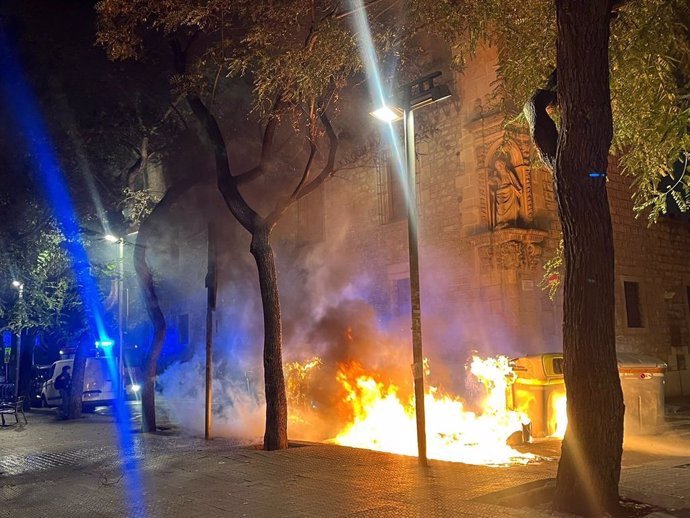 Contenidors cremant a la plaça Joan Amades de Barcelona, després que un grup de manifestants en contra del desallotjament de l'Antiga Massana creessin barricades