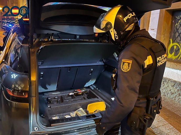 Policía frente al maletero del coche del detenido.