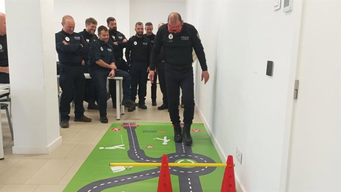 Un agente de educación vial se pone unas gafas que simulan los efectos del alcohol en la conducción.