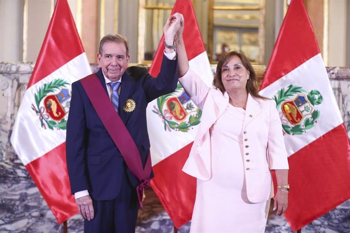 La presidenta de Perú, Dina Boluarte, levanta la mano del opositor venezolano, Edmundo González, tras condecorarle con la Orden del Sol