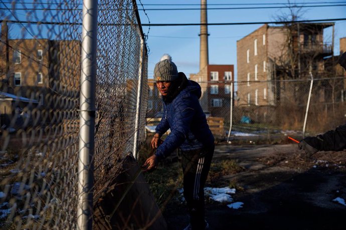 Archivo - January 14, 2024: Rayni Cuadrado, 29, from Venezuela, measures a broken door behind the New Promise Land Missionary Baptist Church, Jan. 11, 2024, in Chicago.