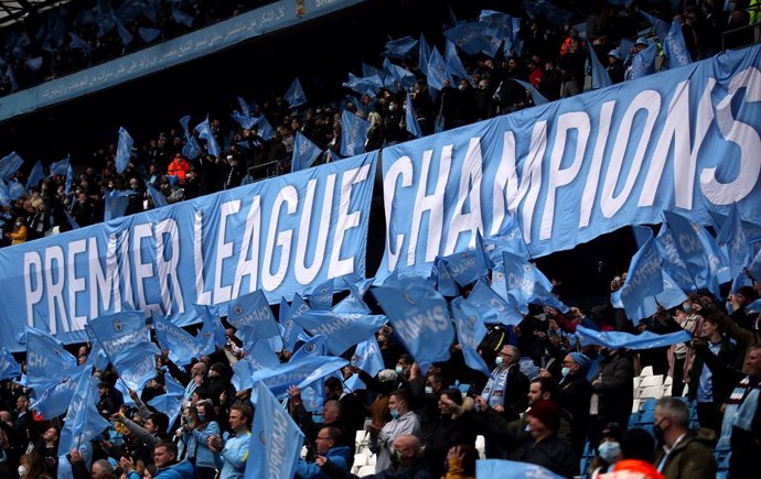 Archivo - 23 May 2021, United Kingdom, Manchester: Manchester City fans wave "Champions" flags in the stands during the English Premier League soccer match between Manchester City and Everton at the Etihad Stadium. Photo: Carl Recine/PA Wire/dpa