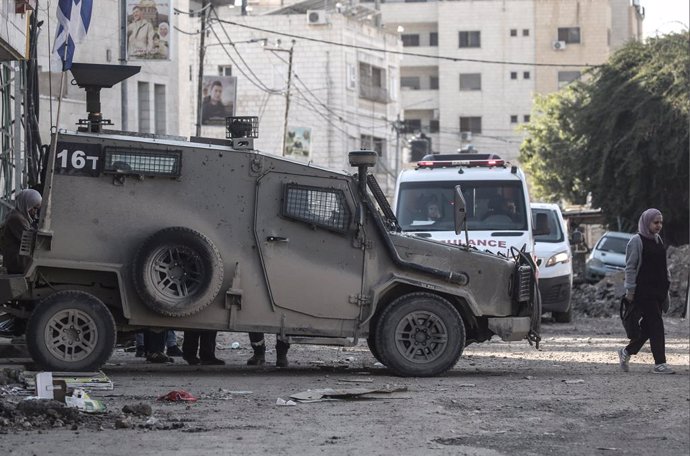 January 29, 2025, Jenin, West Bank, Palestine: A Palestinian walks past an Israeli military vehicle at the entrance to Jenin camp near the city of Jenin in the West Bank, as the Israeli military operation continues in the city of Jenin and Tulkarm, where 