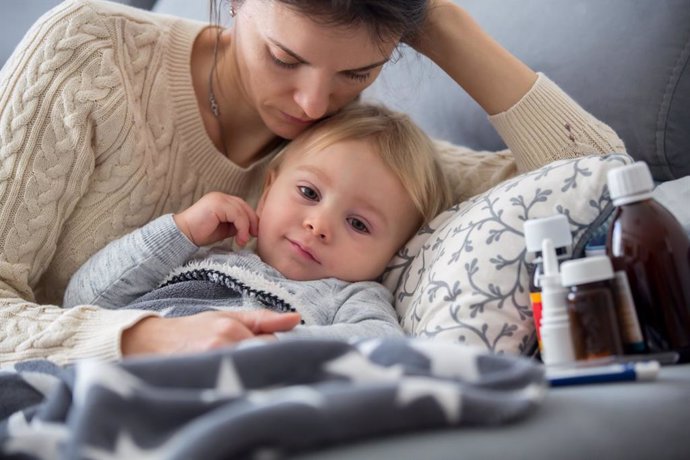 Archivo - Bebé enfermo en la cama cuidado por su madre.