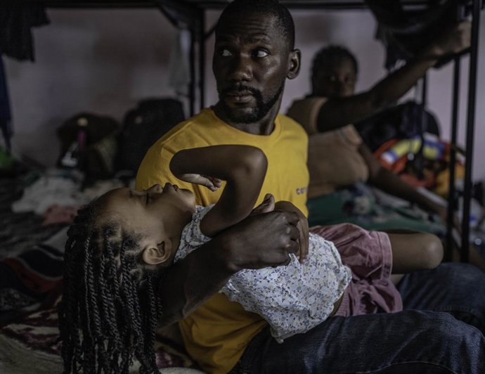 Archivo - April 27, 2022, Ciudad Juarez, NEW MEXICO, USA: Roberto E. Rosales.Edwenson Marcelus(Cq) holds is daughter who has been sick for a week now while he stays at a shelter in Ciudad JuÃ¡rez in late April.  He and his family have remained Mexico sinc