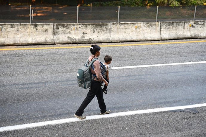 20 January 2025, Mexico, Huehuetan: A woman carries her child on the side of a country road in the hope of reaching the US border. US President Donald Trump plans to sign a series of executive orders to tighten migration policy immediately after taking of