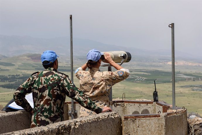 Archivo - GOLAN HEIGHTS, May 10, 2018  A member of the United Nations Disengagement Observer Force (UNDOF) looks through binoculars at an observation post on the Israeli-occupied Golan Heights, on May 10, 2018. UN Secretary-General Antonio Guterres called