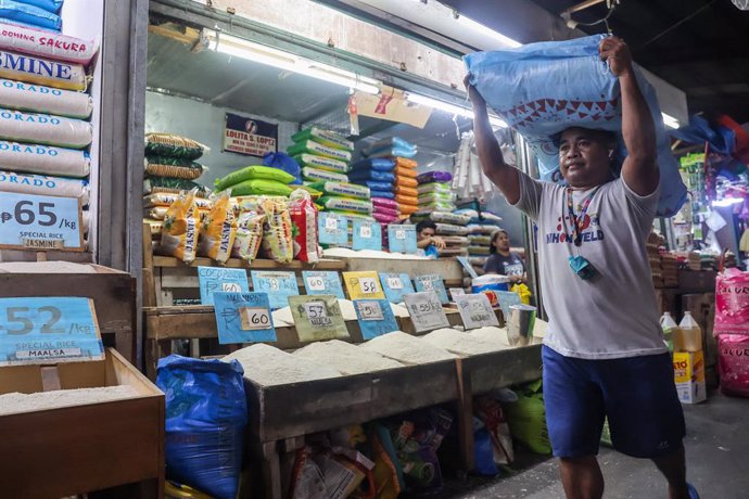 Archivo - QUEZON CITY, Aug. 6, 2024  -- A man carries a sack of rice at a market in Quezon City, the Philippines, Aug. 6, 2024. The Philippines' headline inflation in July has reached its highest rate so far this year, accelerating to 4.4 percent in July 