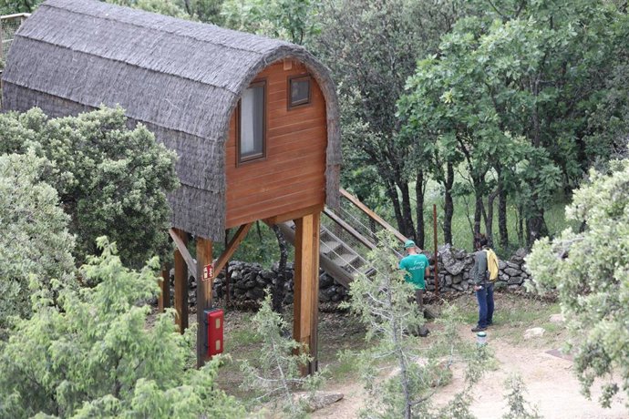 Archivo - Un trabajador del camping le enseña a una clienta una Cabaña en el árbol del Camping Monte Holiday en Gargantilla del Lozoya