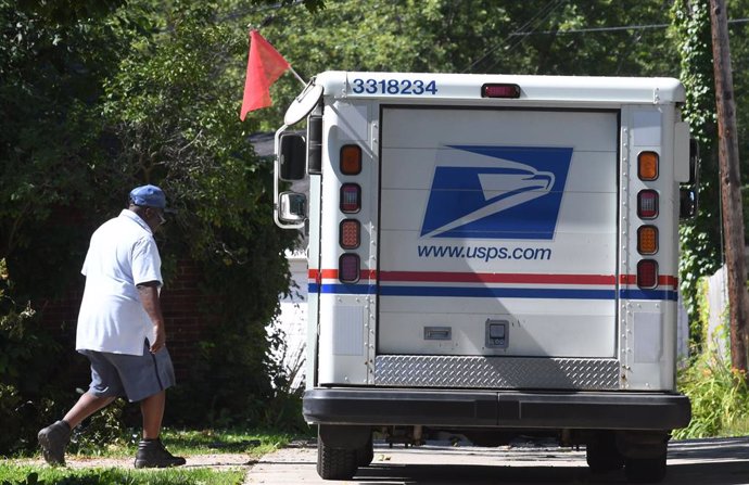 Archivo - FILED - 16 August 2020, US, Racine: A United States Postal Service (USPS) postman returns to his delivery vehicle. After concerns that financial cuts in the US Postal Service could jeopardize the presidential election in November, political resi